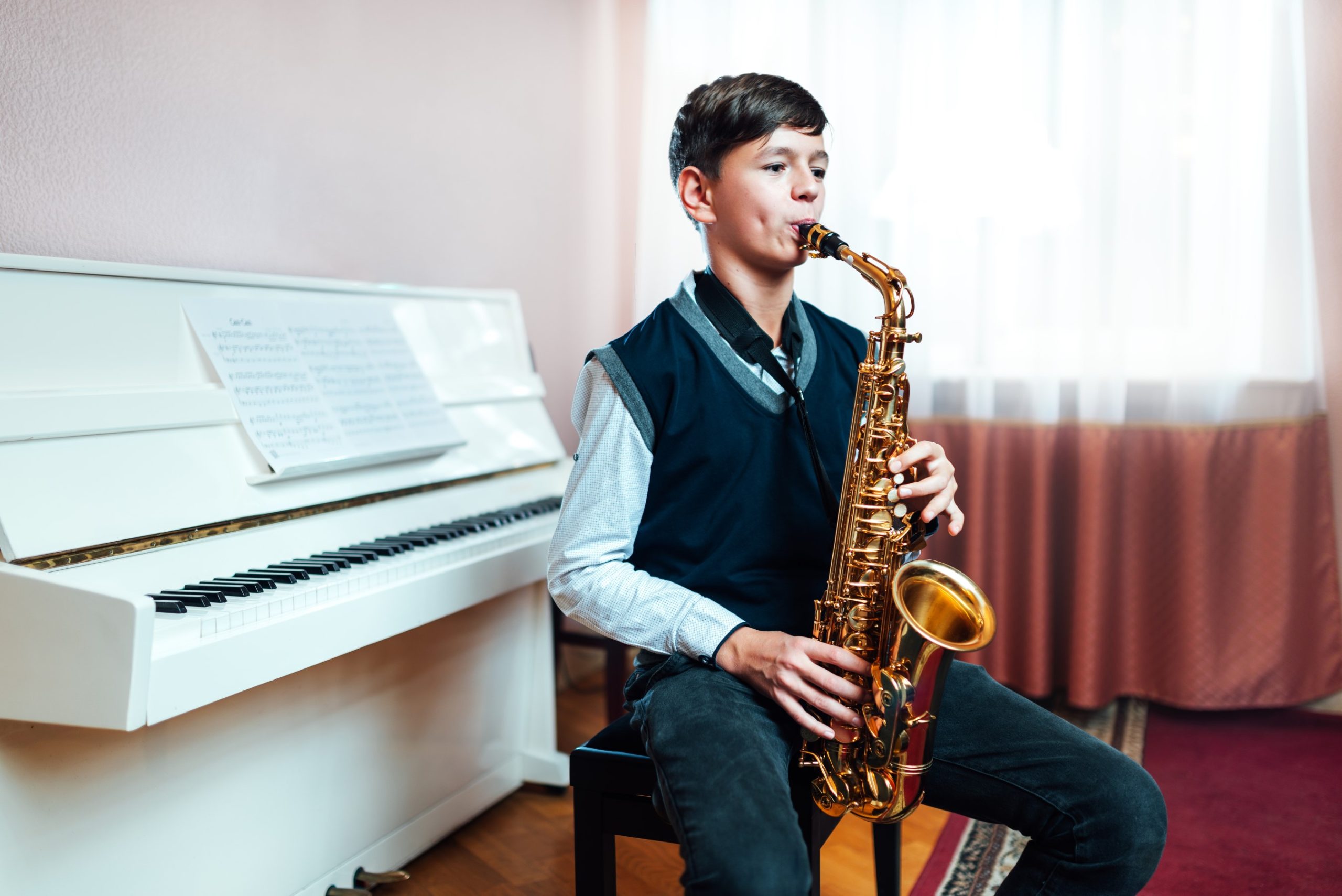 student-boy-plays-saxophone-while-sitting-at-a-mus-2021-08-27-09-32-46-utc.jpg
